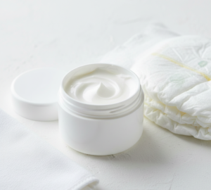 Crema barrera para el pañal del bebé junto a un pañal limpio